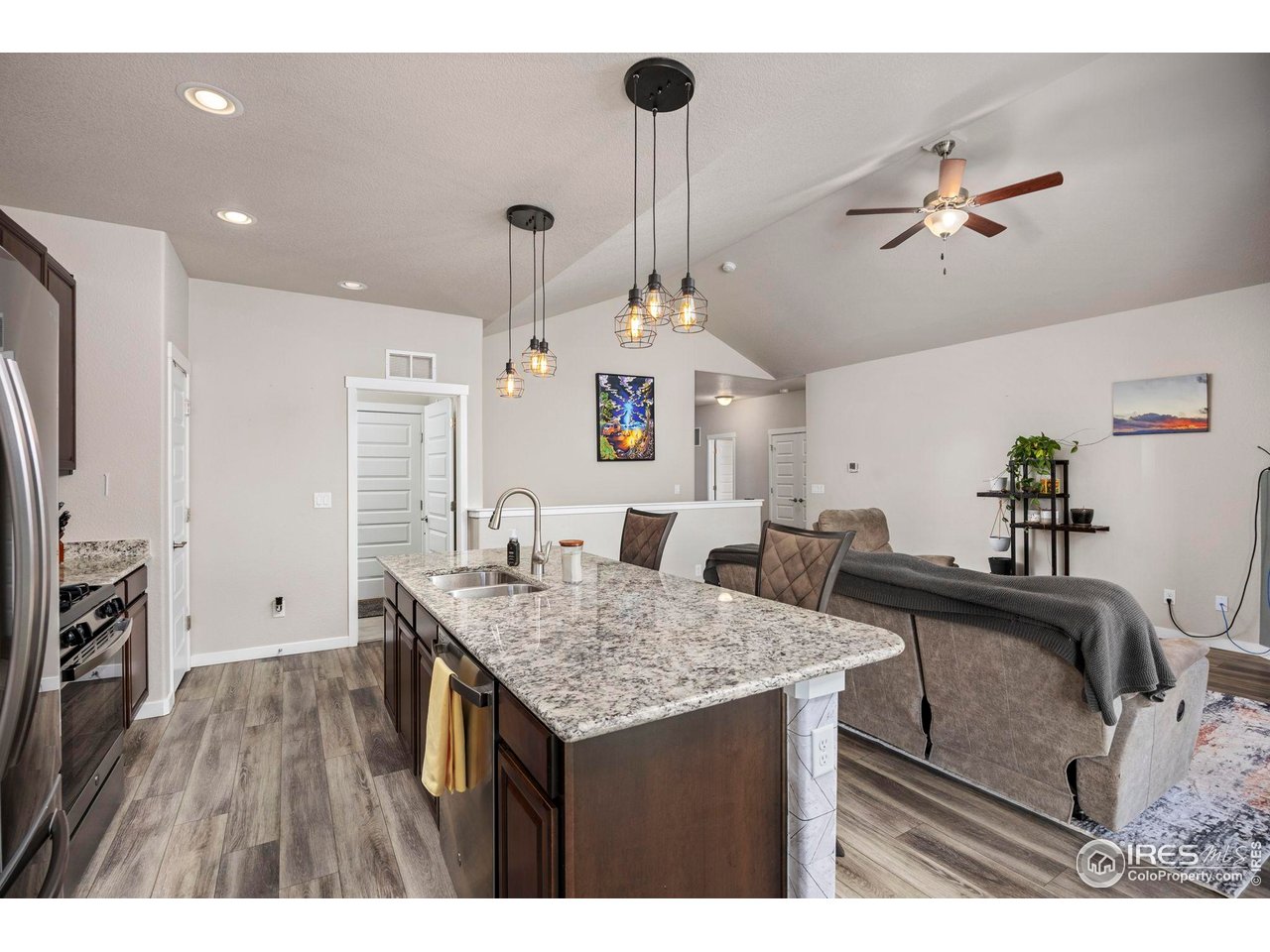 1344 87th Avenue Greeley, CO 80634 - Photo 9 of 31 a kitchen with granite countertop a table and chairs in it