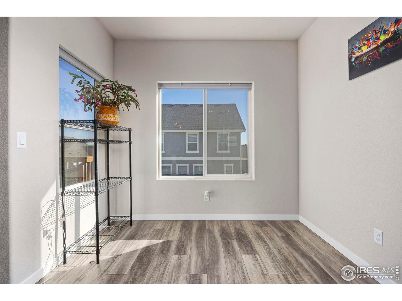1344 87th Avenue Greeley, CO 80634 - Photo 10 of 31 a view of an empty room with wooden floor and a window