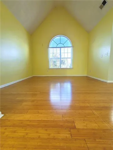 a view of a large space with a large window and wooden floor