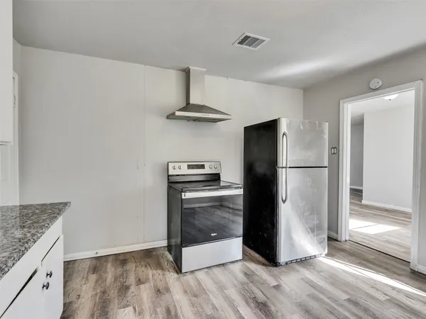 a kitchen with a refrigerator and a stove top oven