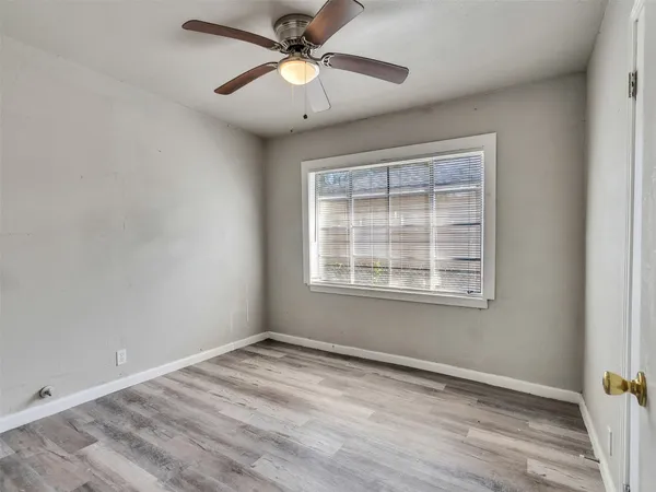 an empty room with a window and a fan