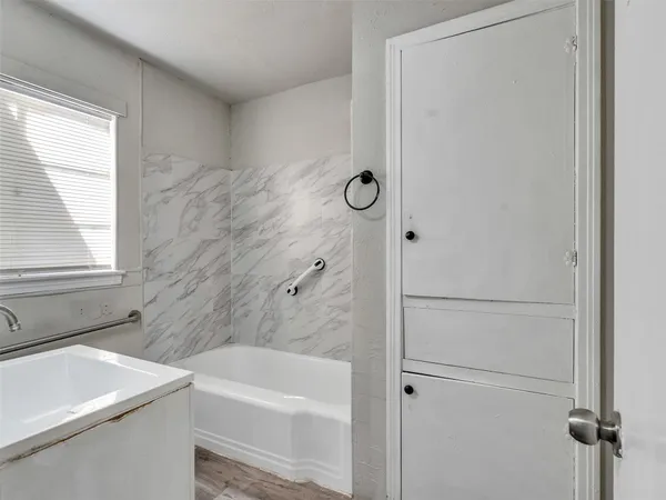 a bathroom with a bathtub a window and a shower