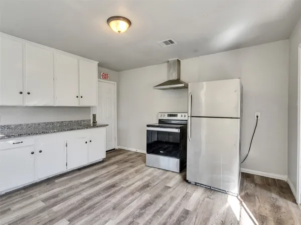 a kitchen with granite countertop a refrigerator a stove and a sink