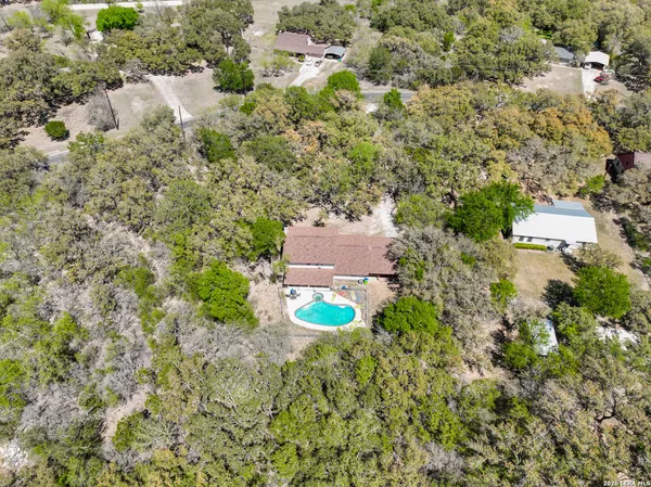 an aerial view of a house with a yard and trees
