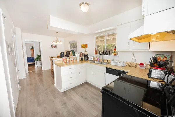 a kitchen that has a lot of cabinets a sink and appliances in it