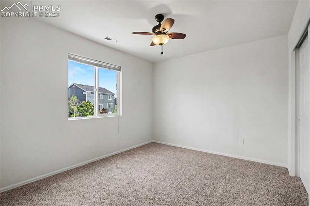 12210 Crystal Downs Road Peyton, CO 80831 - Photo 23 of 40 an empty room with window and ceiling fan