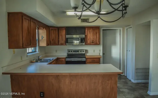 a kitchen with stainless steel appliances granite countertop a sink a stove and a refrigerator
