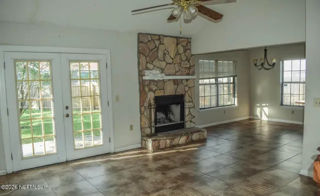 a view of an empty room with a fireplace and a window