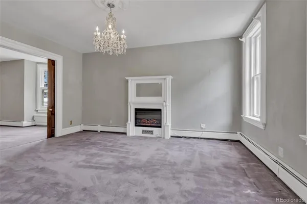 a view of an empty room with a window and fireplace