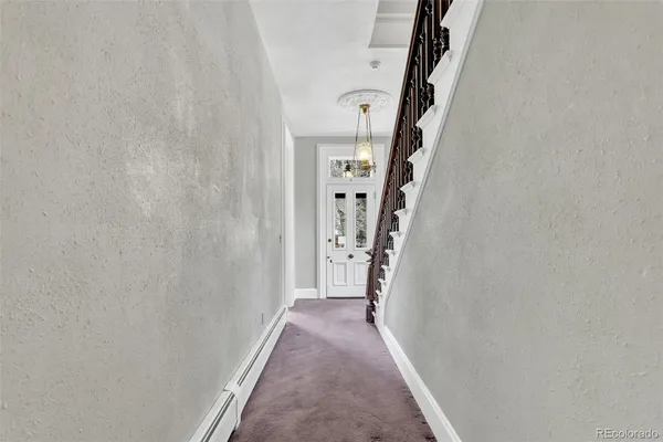 a view of a hallway with wooden floor and entryway