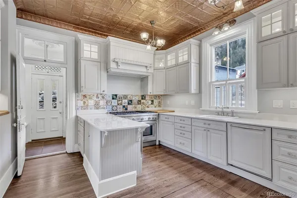 a kitchen with granite countertop white cabinets and white appliances