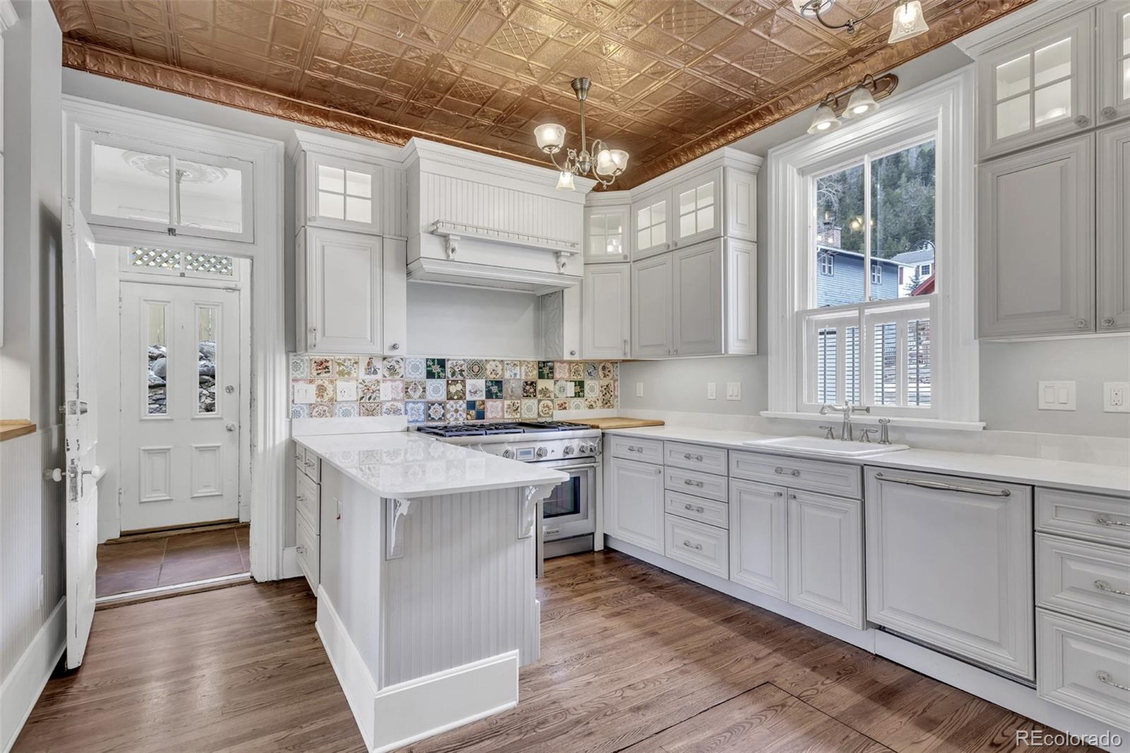 300 Rose Street Georgetown, CO 80444 - Photo 4 of 49 a kitchen with granite countertop white cabinets and white appliances