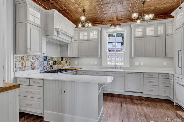 a kitchen with cabinets wooden floor and a window