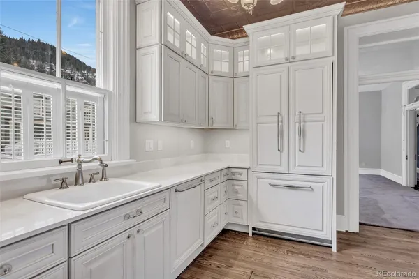 a kitchen with white cabinets and sink