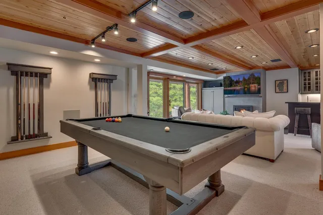 a living room with pool tables and a chandelier
