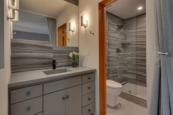 a bathroom with a sink a toilet and shower
