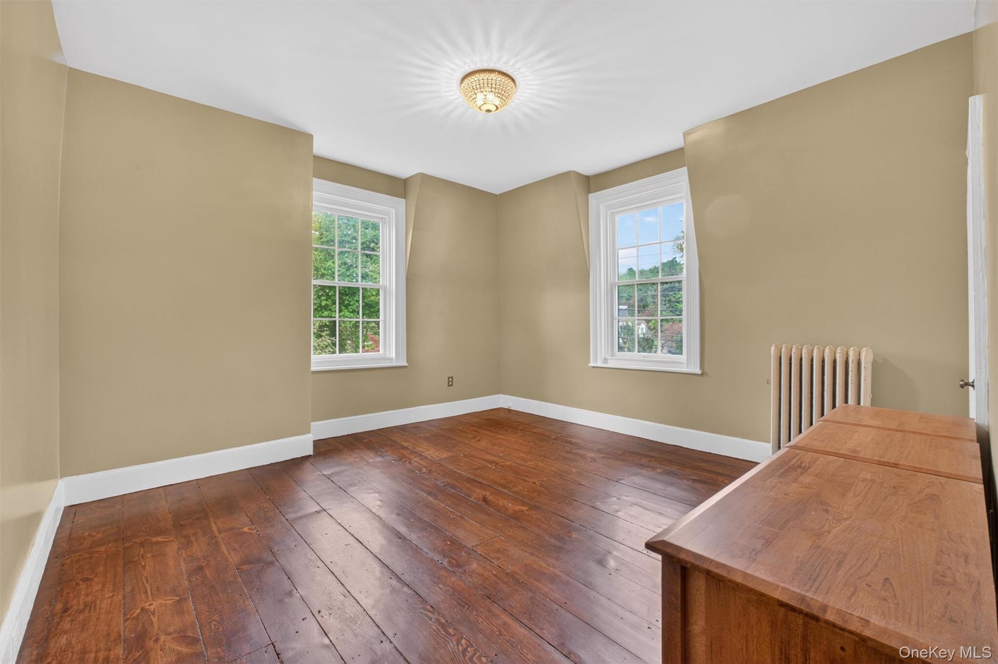 121 Old Glenham Road Fishkill, NY 12524 - Photo 28 of 50 Room featuring wide plank hardwood flooring, two large double-hung windows, and a ceiling-mounted light fixture.