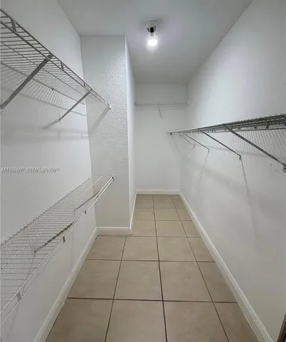 a view of a room with white walls and tiles