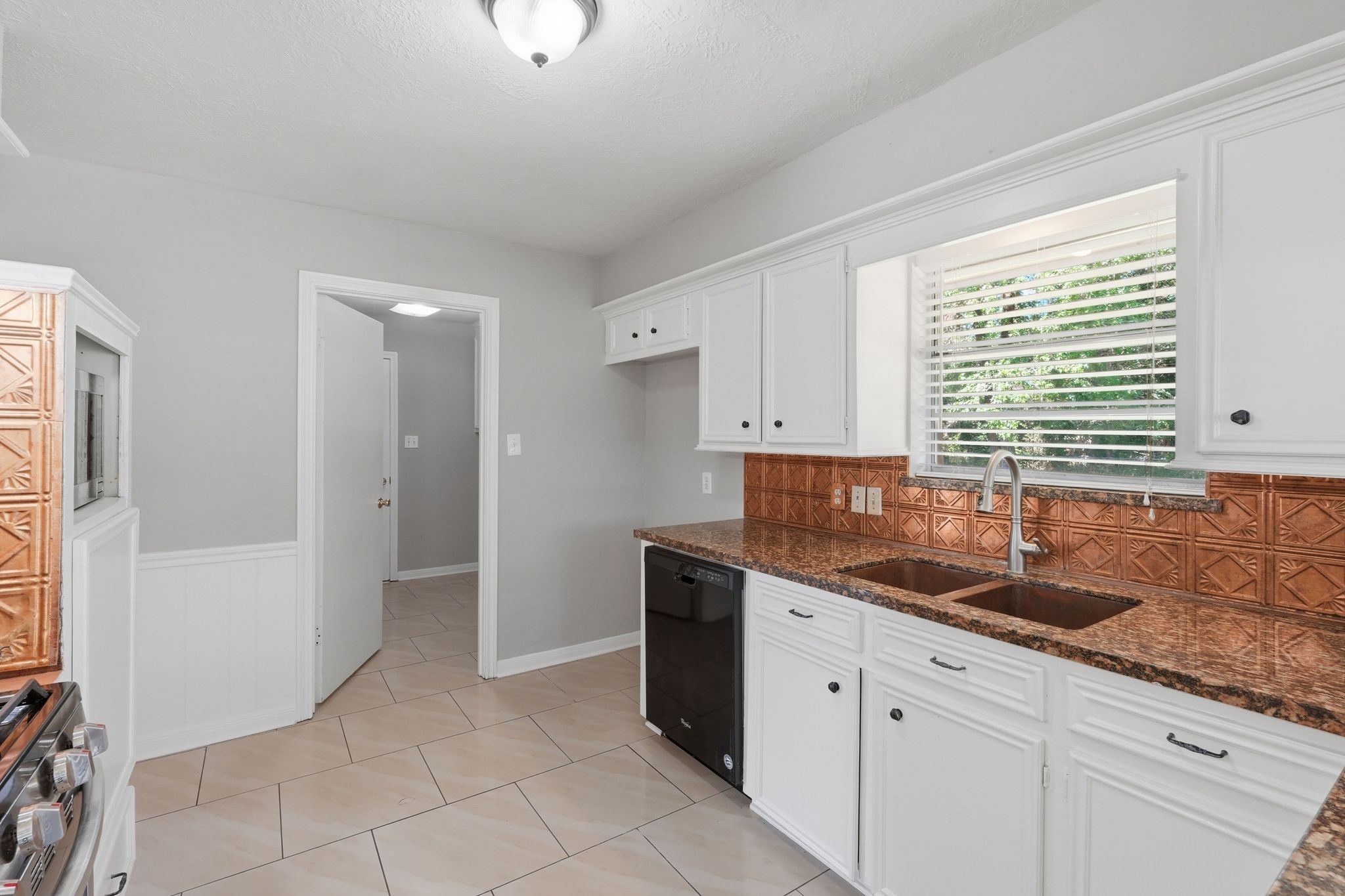 25611 Timberlane Drive Spring, TX 77386 - Photo 14 of 38 a kitchen with granite countertop white cabinets and window