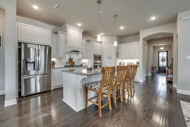 a large kitchen with granite countertop lots of counter space a sink and appliances