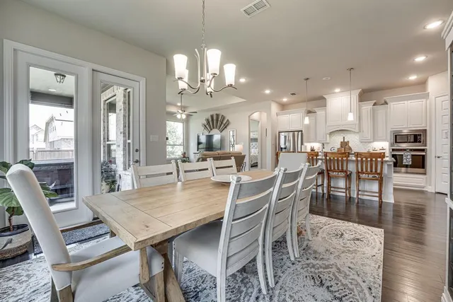 a kitchen with granite countertop white cabinets and stainless steel appliances