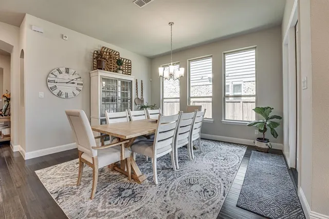 a kitchen with stainless steel appliances kitchen island granite countertop a table chairs sink and cabinets