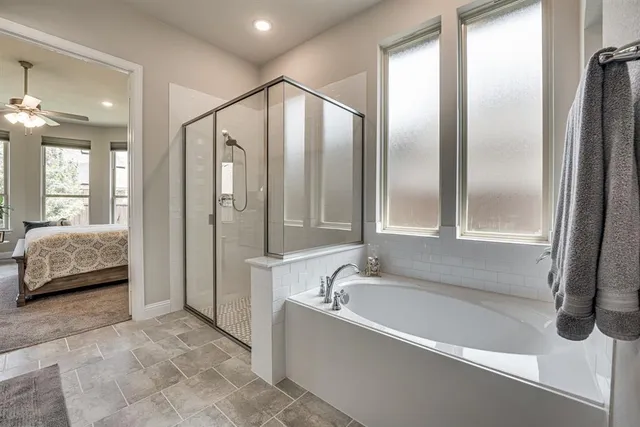 a spacious bedroom with a bed and a dresser next to a window