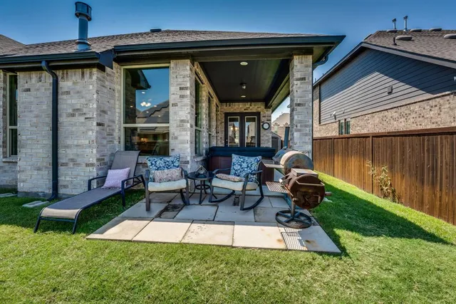a view of an house with backyard and a tree