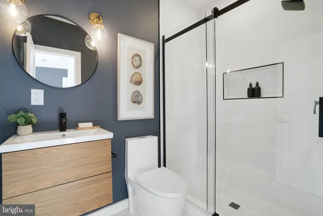 a bathroom with a sink a toilet and shower