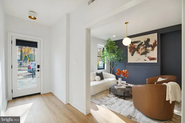 a living room with furniture and a painting on the wall