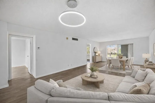 a living room with furniture and a wooden floor