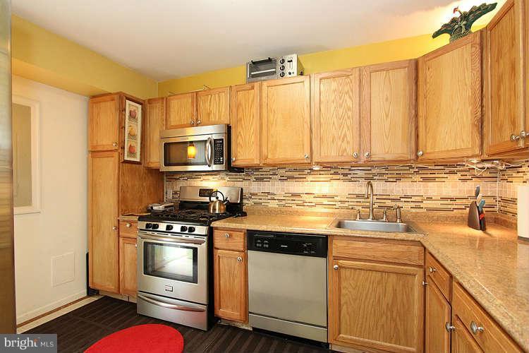 3343 Claridge Court Silver Spring, MD 20902 - Photo 6 of 20 a kitchen with granite countertop a stove top oven microwave and cabinets