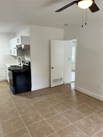 a kitchen with stainless steel appliances a sink a stove a refrigerator cabinets and a dining table