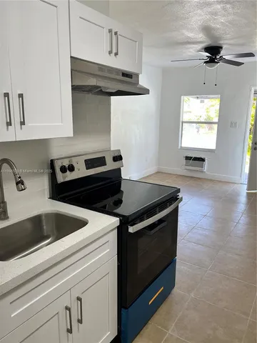 a kitchen with granite countertop a stove and a sink