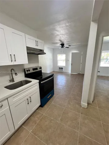 a kitchen with a sink a stove and cabinets