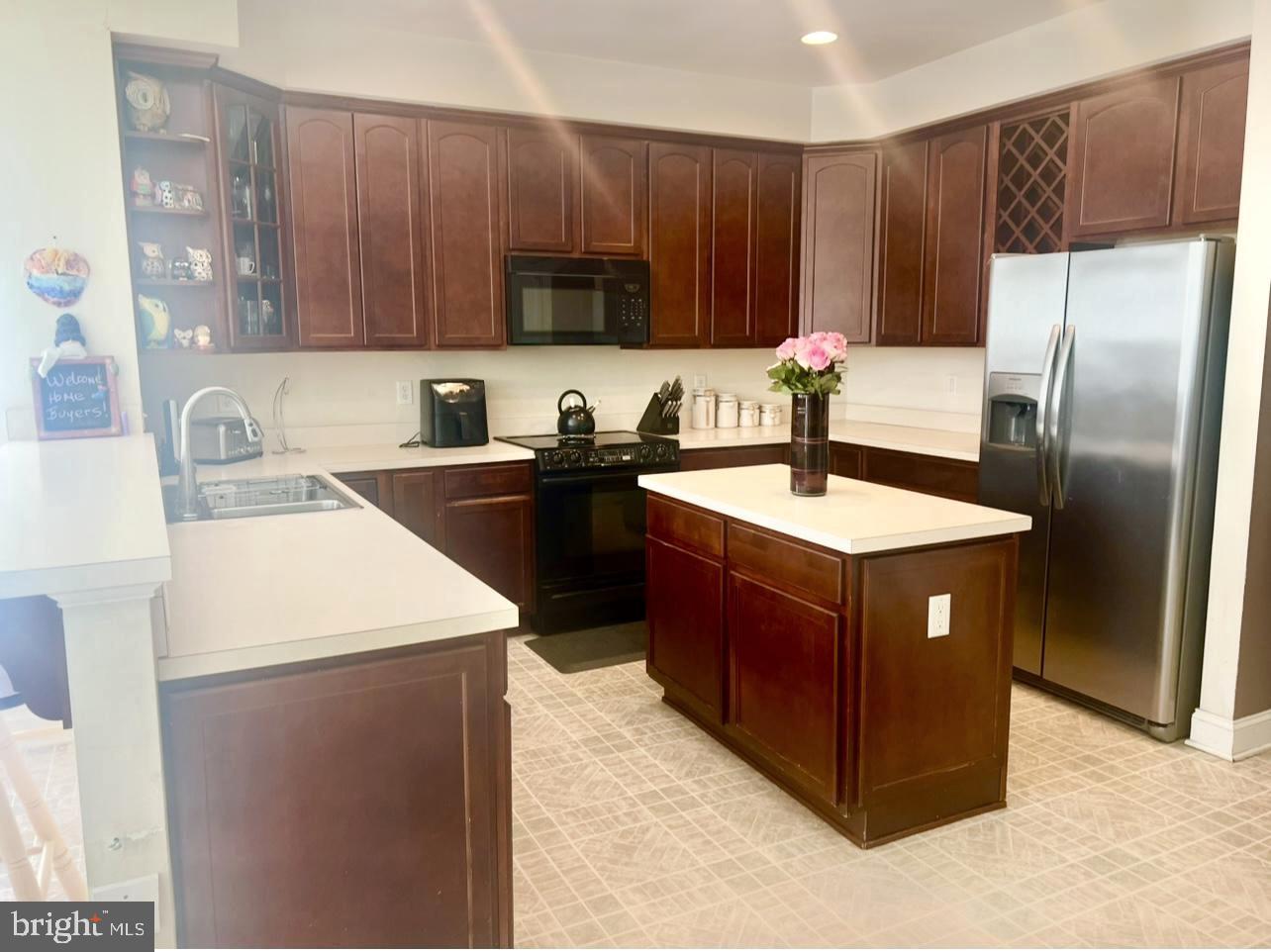 5113 Robins Perch Lane Perry Hall, MD 21128 - Photo 4 of 16 a kitchen with stainless steel appliances granite countertop a sink a refrigerator and a wooden cabinets