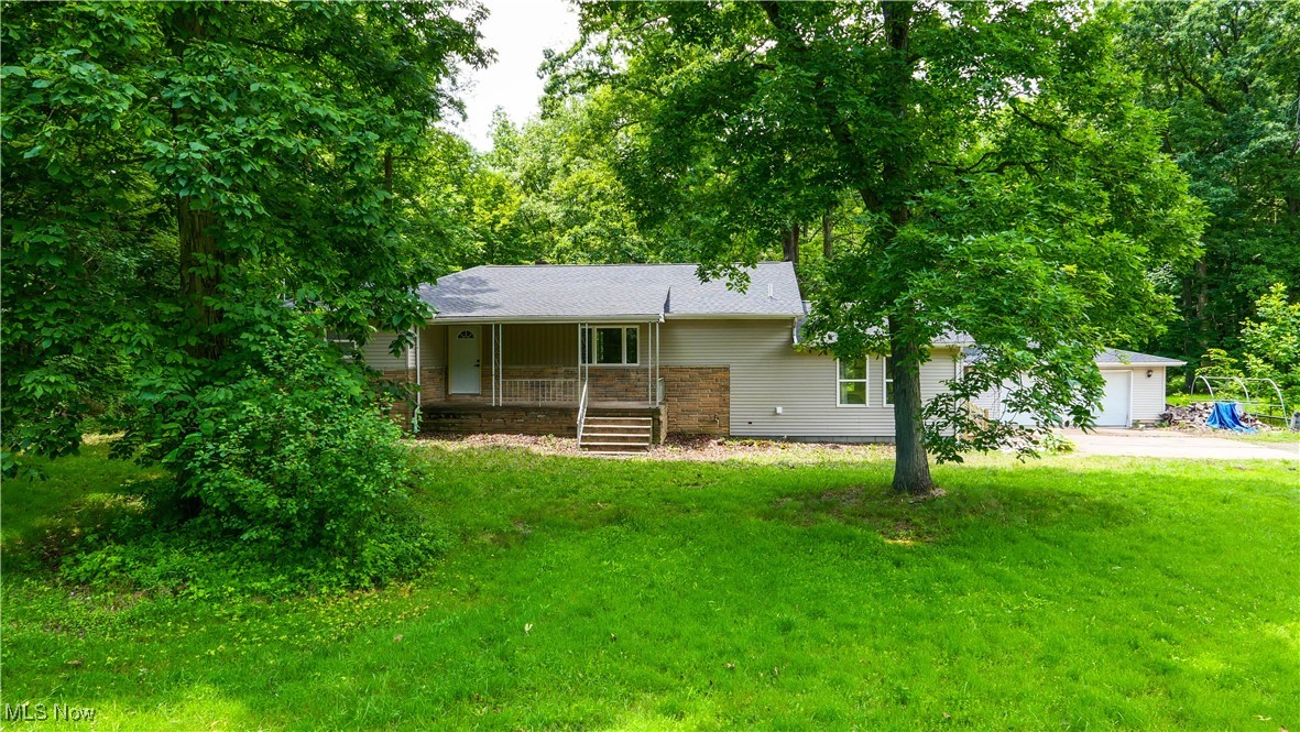 4869 Phillips Rice Road Cortland, OH 44410 - Photo 17 of 33 Ranch-style house with concrete driveway, a front yard, a porch, and a garage