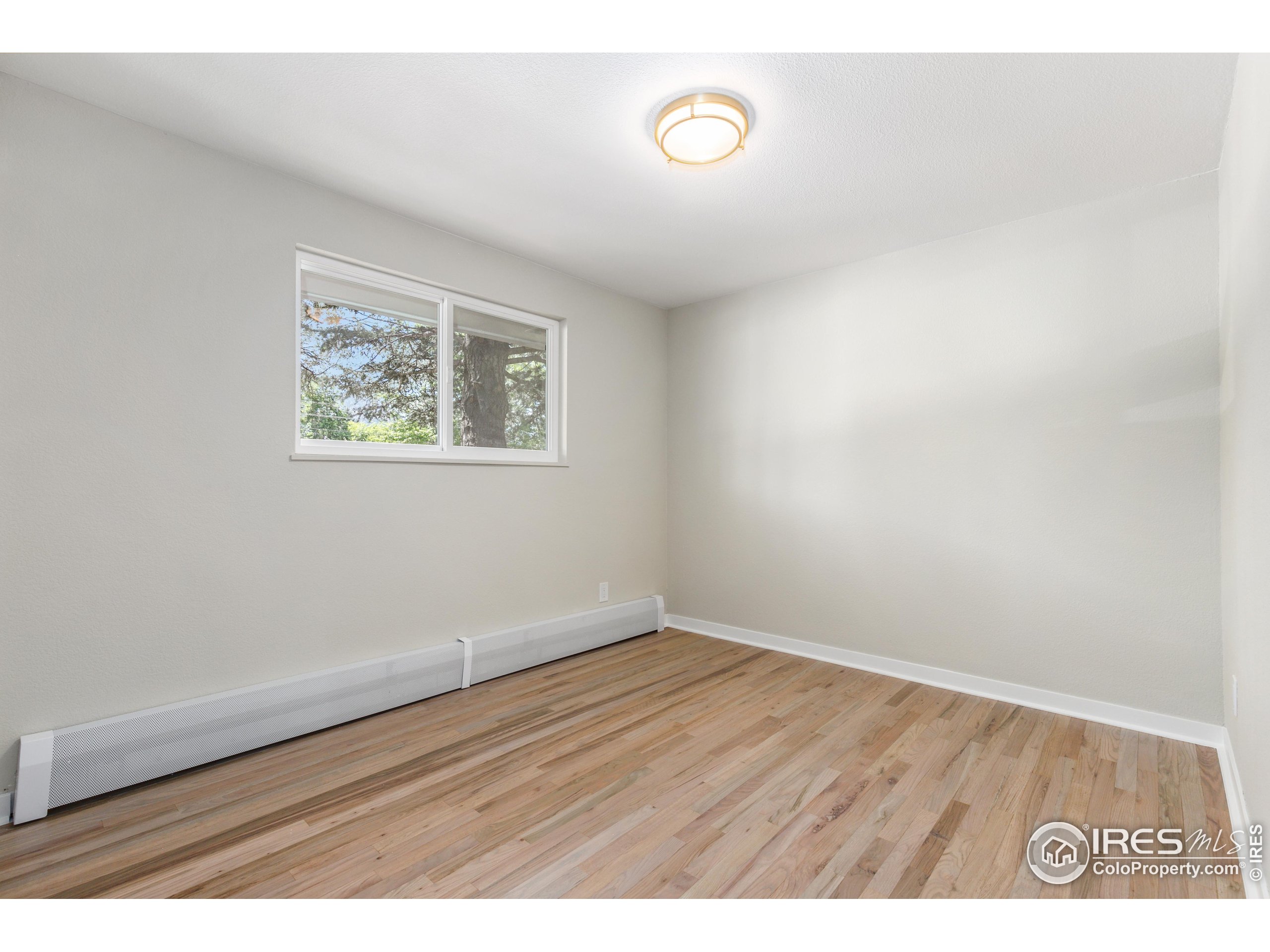 1120 Hartford Drive Boulder, CO 80305 - Photo 20 of 40 an empty room with wooden floor and windows
