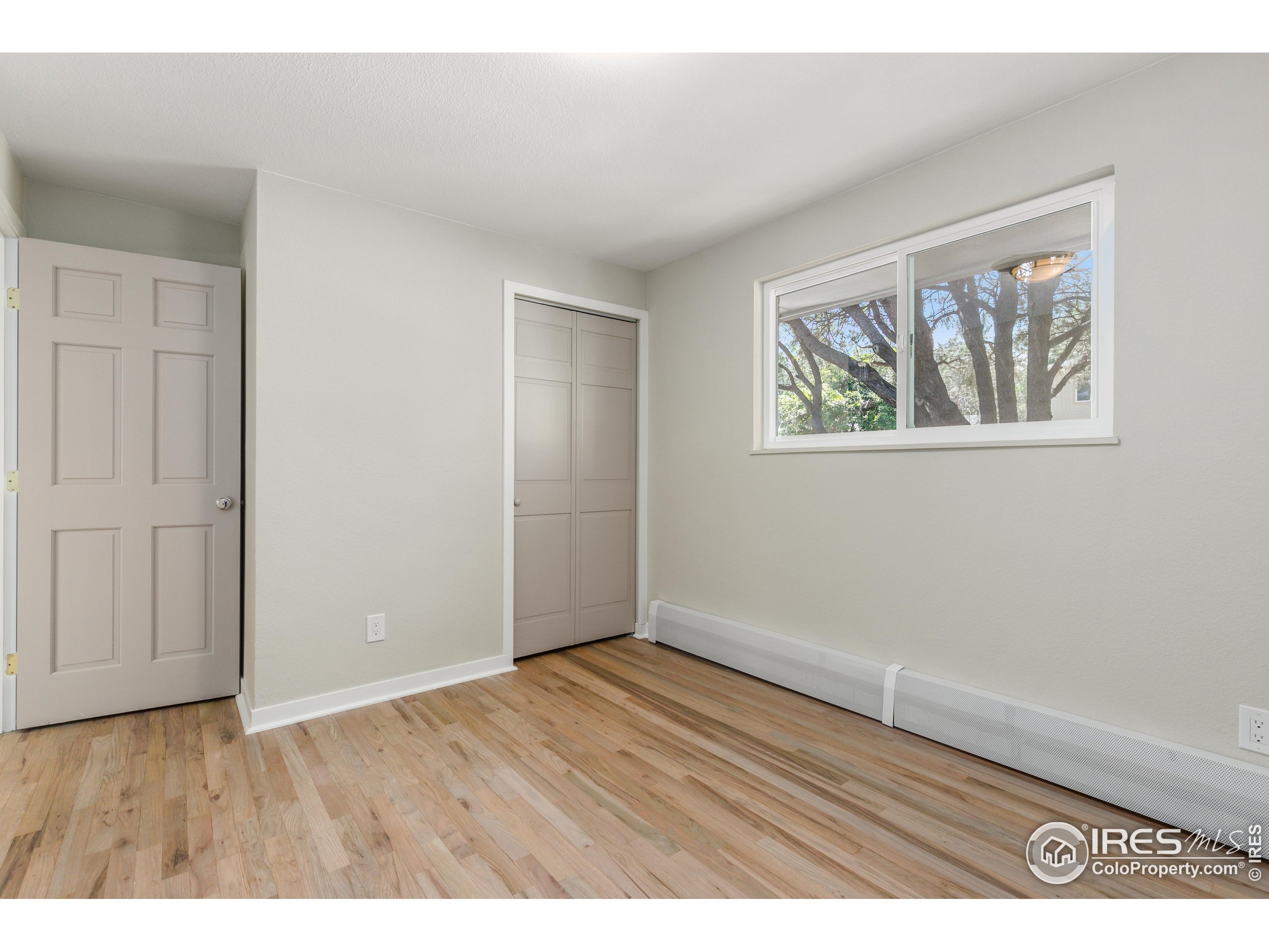 1120 Hartford Drive Boulder, CO 80305 - Photo 22 of 40 an empty room with wooden floor and windows
