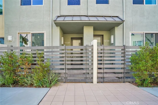 a view of a house with large windows and plants