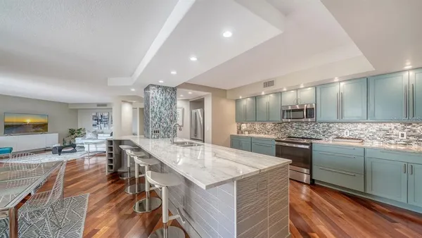 a large kitchen with kitchen island a stove a sink a dining table and chairs