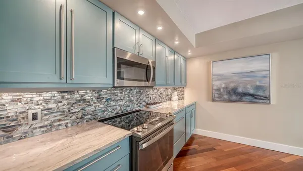 a kitchen with stainless steel appliances granite countertop a stove and a microwave