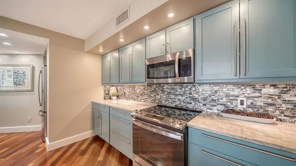 a view of a kitchen sink and wooden floor