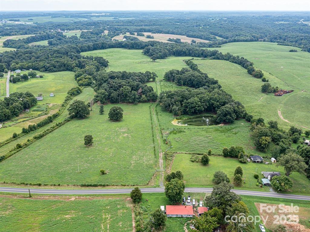 Tract B Rock Hole Road Stanfield, NC 28163 - Photo 22 of 23 an aerial view of green landscape with trees houses and lake view
