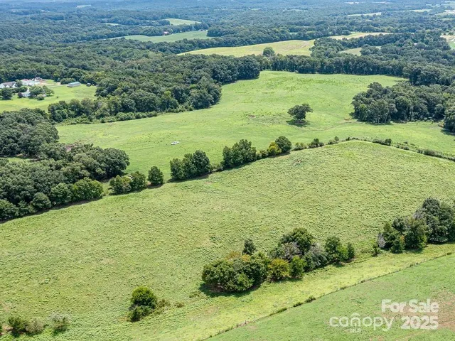 an aerial view of a houses with a yard and lake view