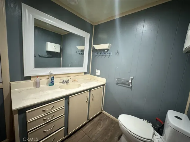 a bathroom with a granite countertop sink vanity mirror and toilet
