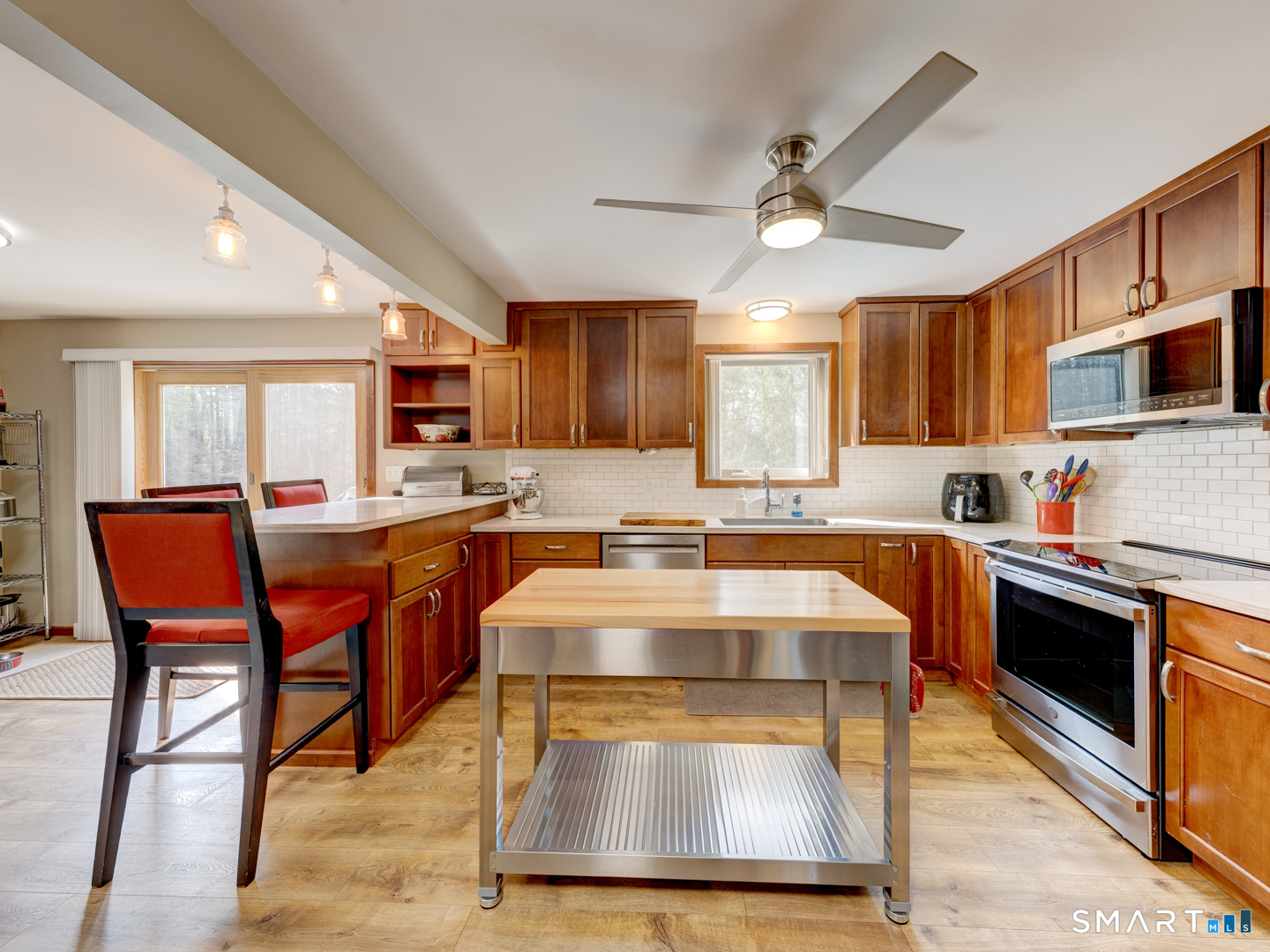 97 Lair Road New Hartford, CT 06057 - Photo 15 of 39 a kitchen with stainless steel appliances granite countertop a stove top oven a sink dishwasher a dining table and chairs with wooden floor
