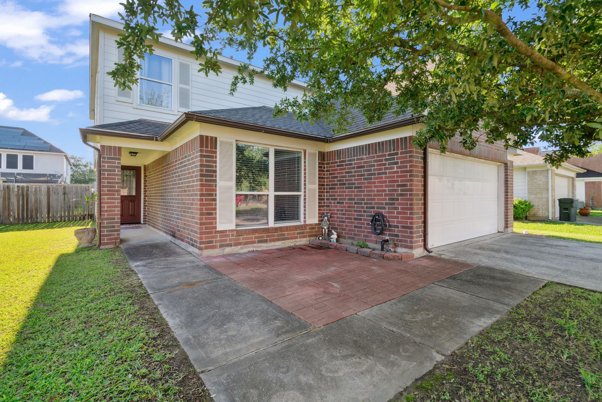 a view of a house with a yard and large tree