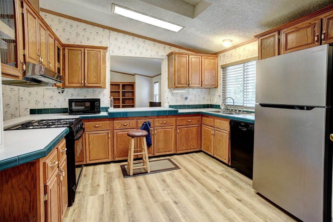 243 Piney Ridge Drive Bastrop, TX 78602 - Photo 14 of 40 a kitchen with stainless steel appliances granite countertop a stove a sink dishwasher and a refrigerator