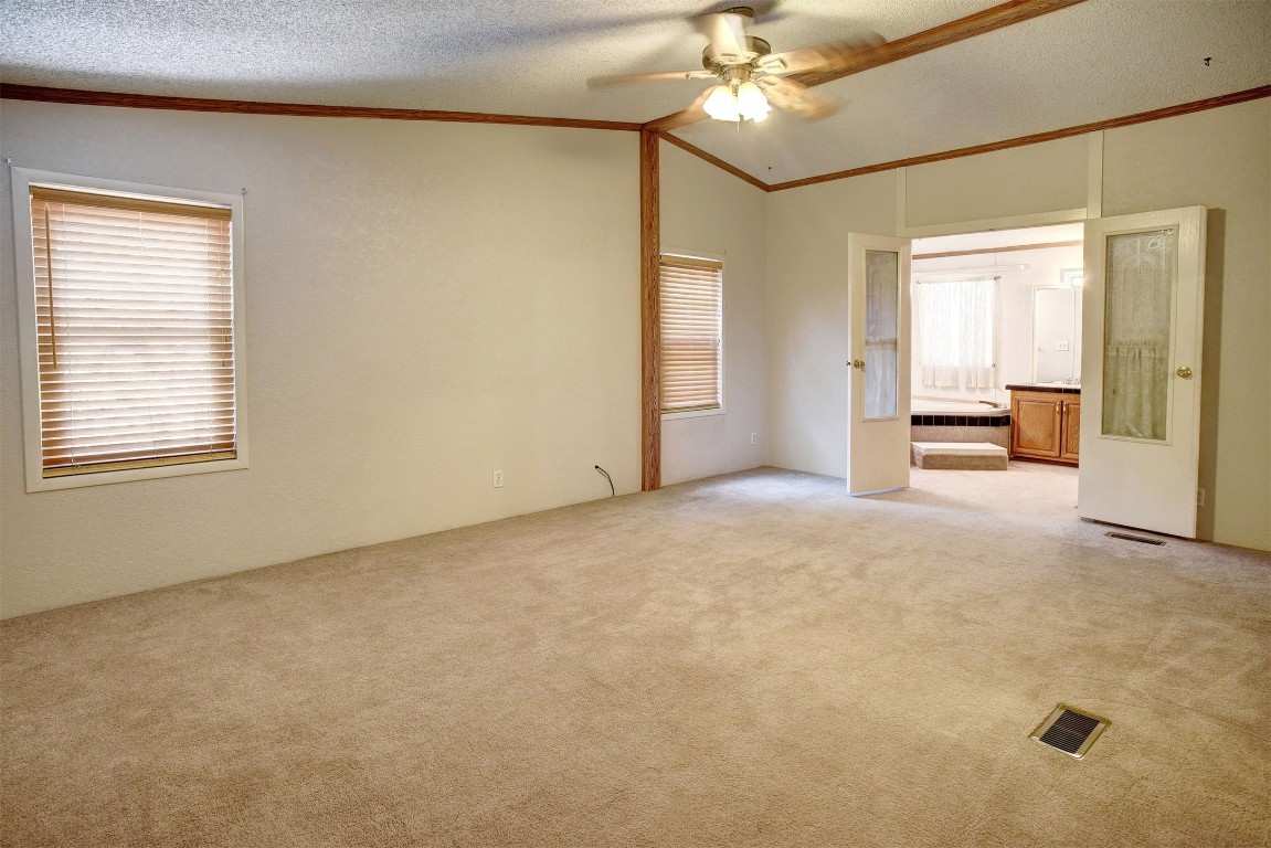 243 Piney Ridge Drive Bastrop, TX 78602 - Photo 17 of 40 an empty room with chandelier fan and windows